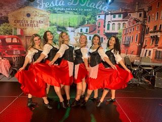 6 girls dressed in traditional Italian outfits in red and green.